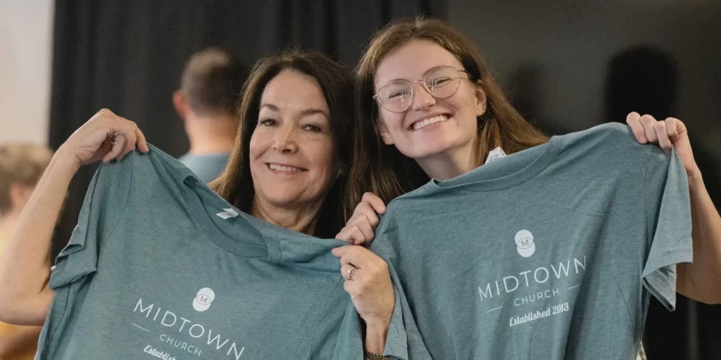 Katie and Brenda holding midtown shirts
